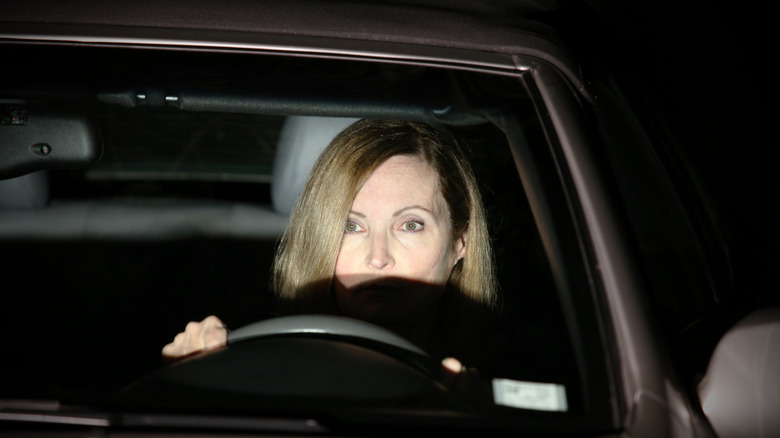 Woman driver facing bright headlights