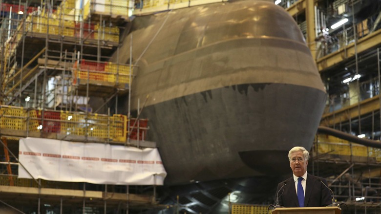 UK Defence Secretary Michael Fallon with submarine being constructed