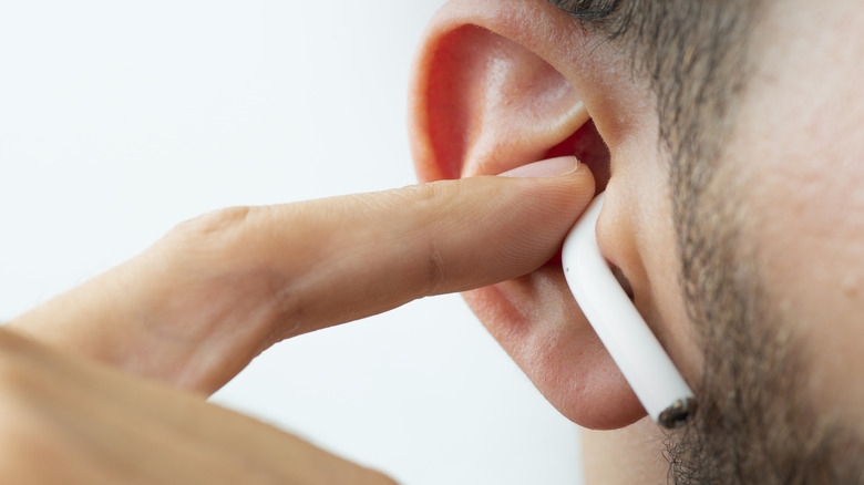 Man adjusting AirPod in his ear