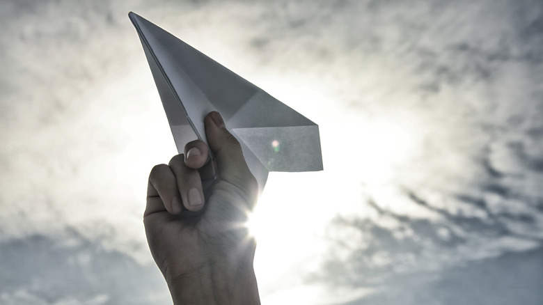 paper airplane held in hand