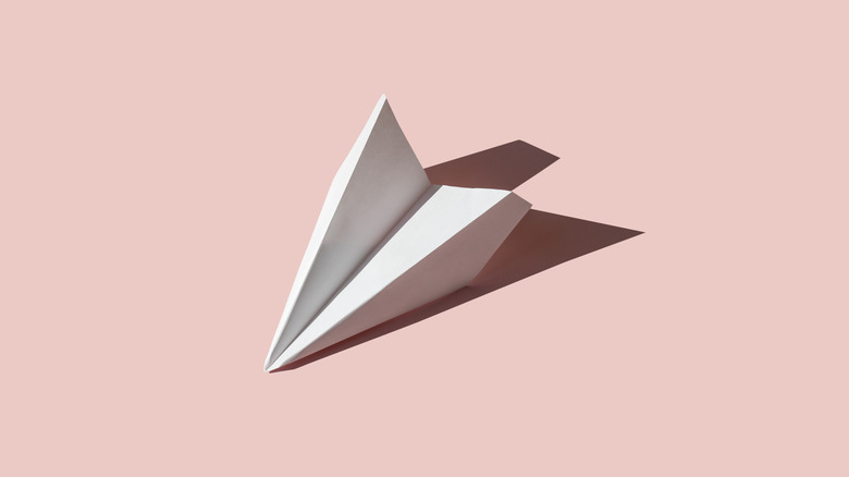 A paper airplane on pink background