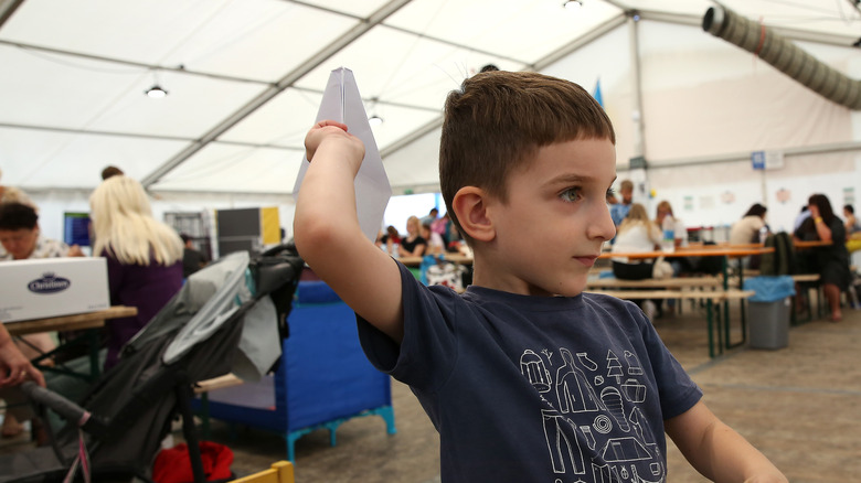 Child throwing a paper airplane