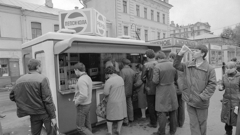 People wait in line to drink from a Pepsi vendor in the Soviet Union