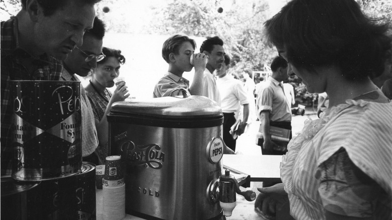 Moscow citizens line up to sample drinks from the Pepsi Cola booth at the American Exhibition