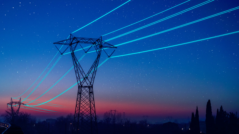 Transformers holding up glowing power lines.