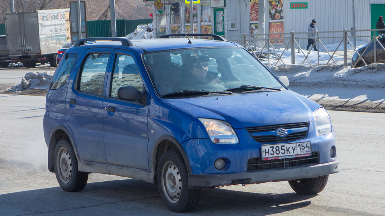 A blue Suzuki Ignis being driven on the road