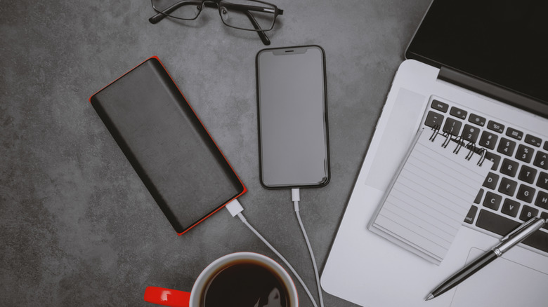 A smartphone and laptop  eing charged using a power bank