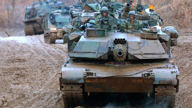 U.S. Army soldiers in a row of M-1 tanks, and other military vehicles, arrive for training in preparation for any possible surprise attack by North Korea, near the demilitarized zone (DMZ), March 6, 2003 in Paju, South Korea.