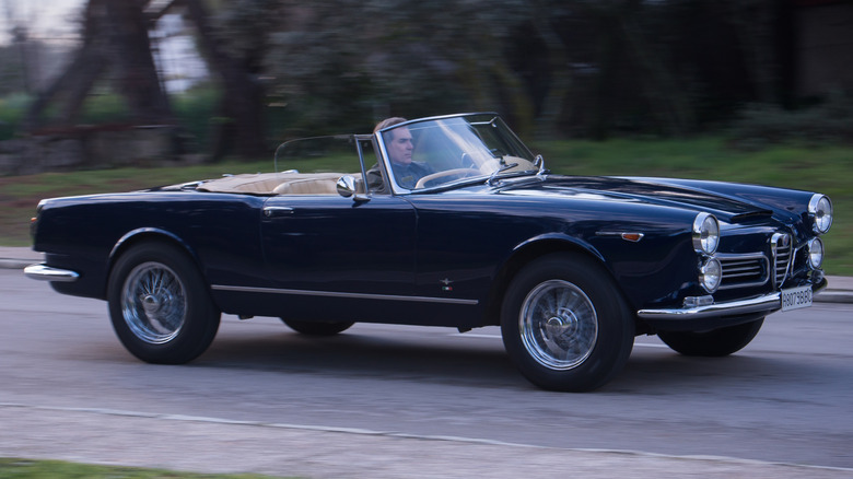 A dark blue Alfa Romeo 2600 on a country road.