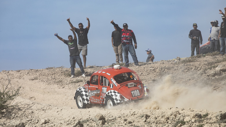 Baja bug racing past spectators