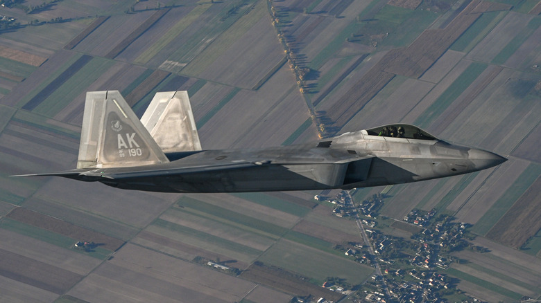 F-22 flies over fields