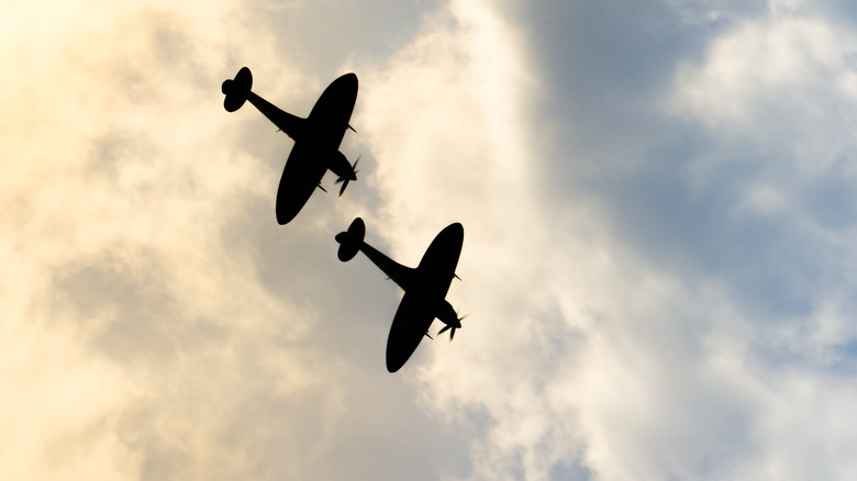 Two flying silhouetted Supermarine Spitfires