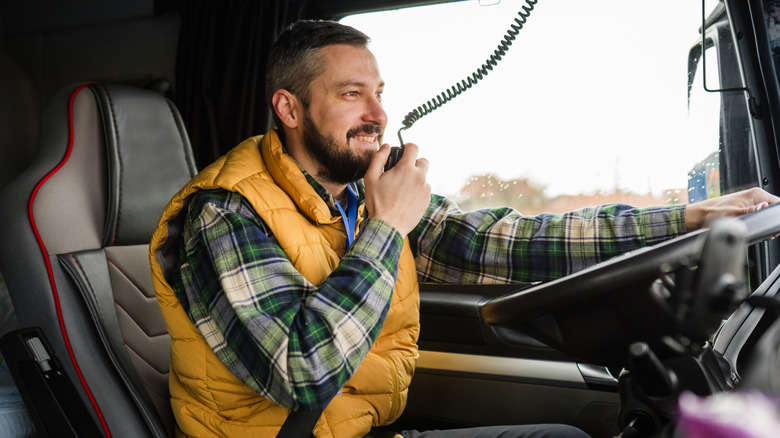 Trucker in cab talking on CB radio