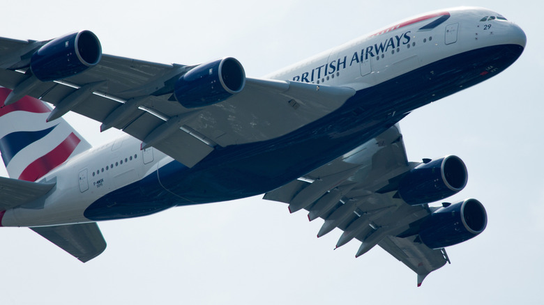 An Airbus A380 operated by British Airways flies overhead, showing off its iconic four engines