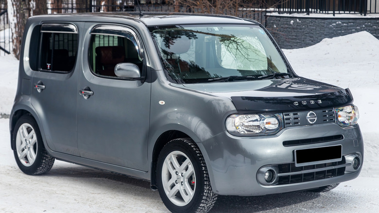 A gray Nissan Cube parked outdoors during winter