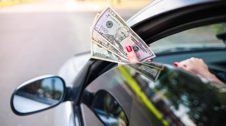 dollar bills handed through car window