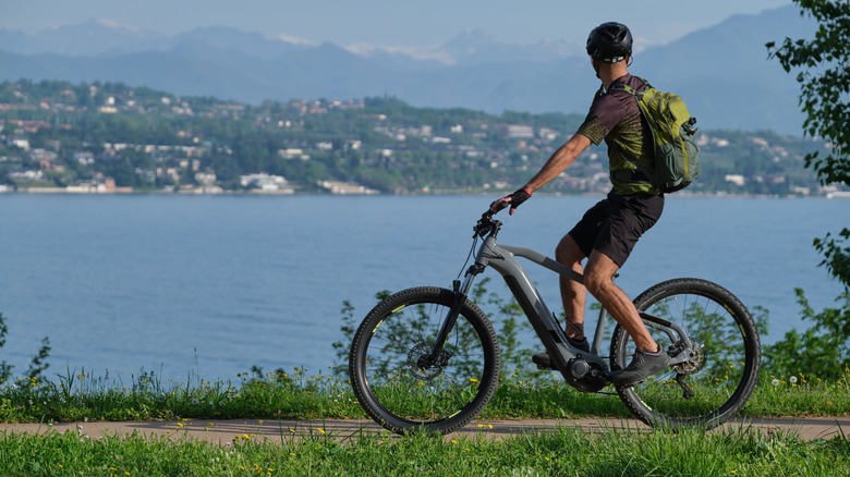 A man on an eBike, overlooking a lake