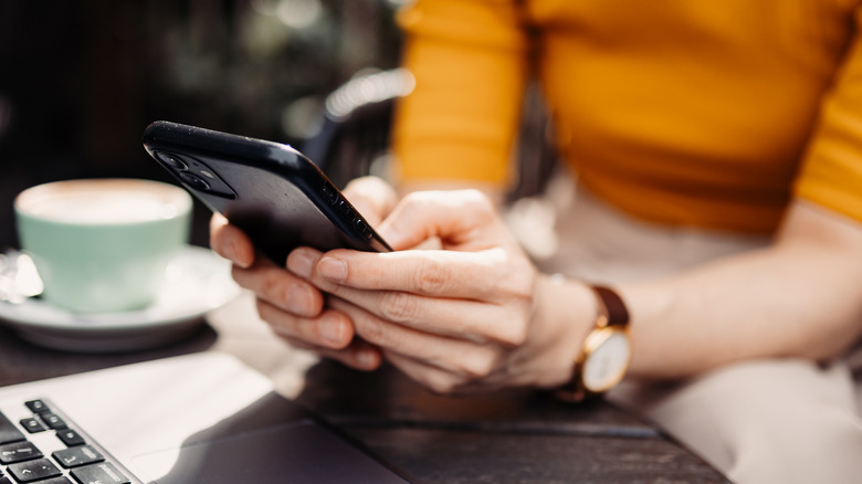 woman using iphone and laptop