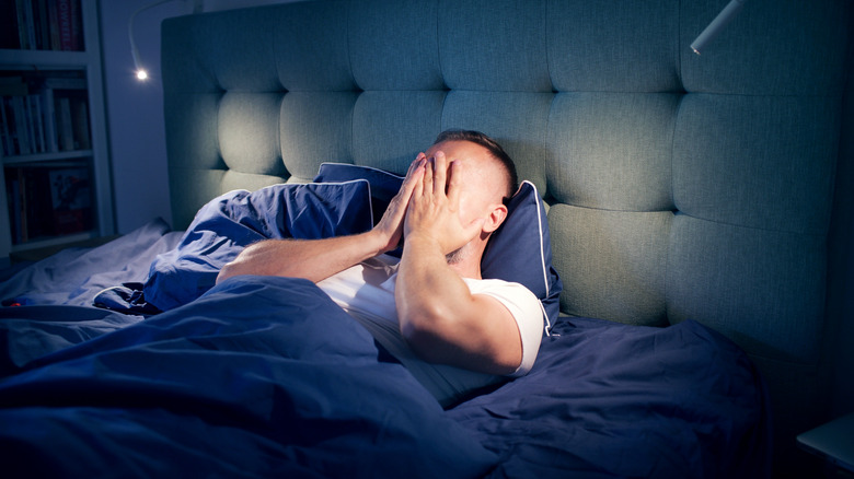 Man struggling to sleep lights insomnia