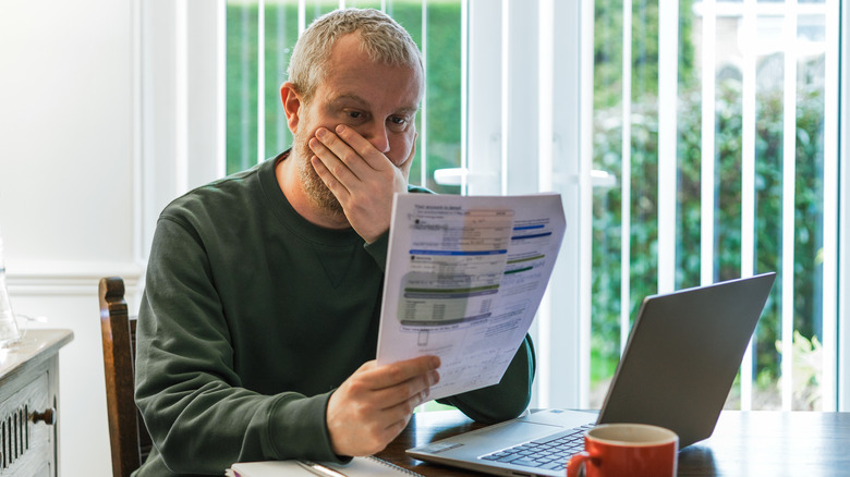 Man looking at energy bill electric cost