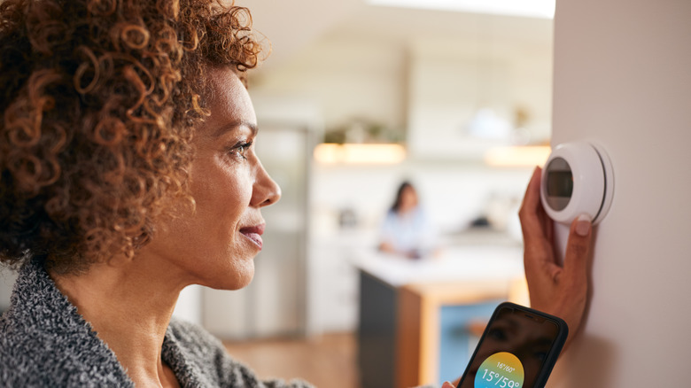 woman and smart thermostat