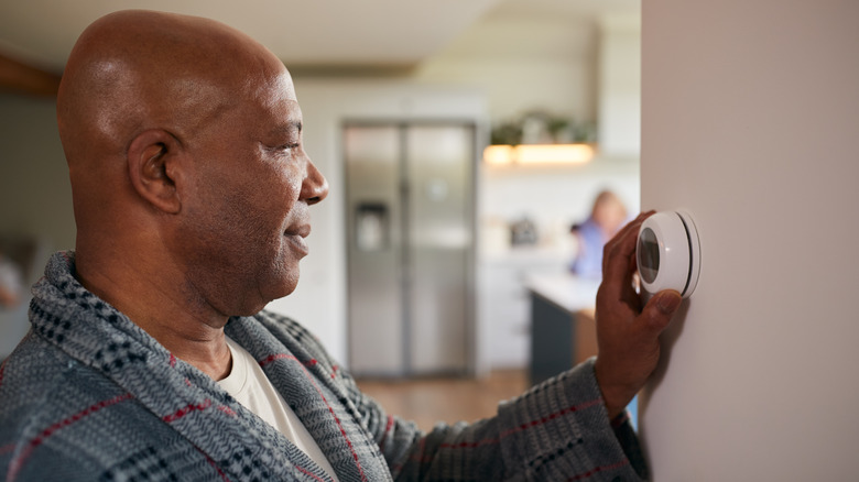 man and smart thermostat