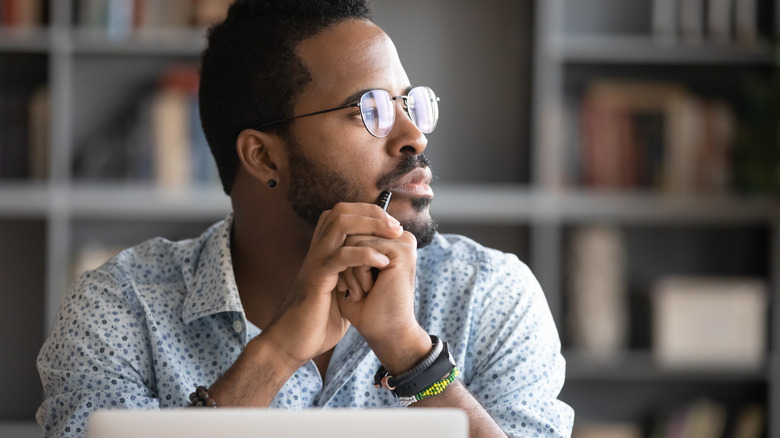 person staring away from laptop