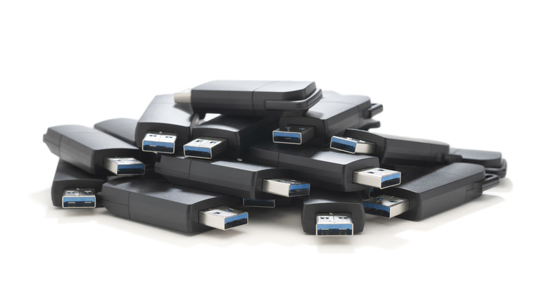 heap of USB flash drives on white background