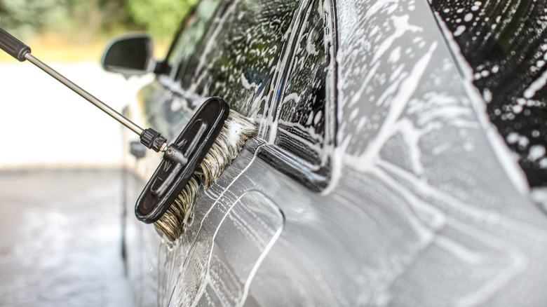 Washing a car with a brush