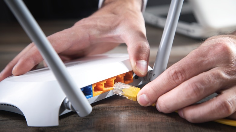 man fixing wifi router cable