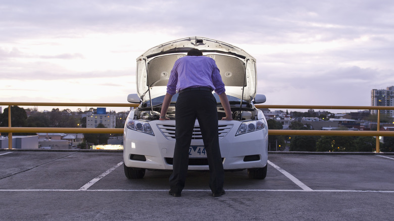 Man looking at car engine