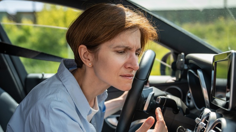 person smelling their car