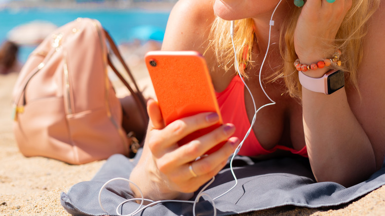 woman using phone on the beach