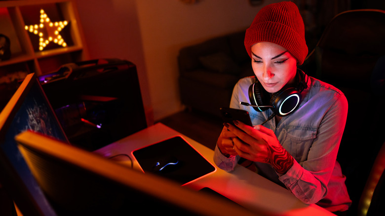 woman using iPhone at gaming desk