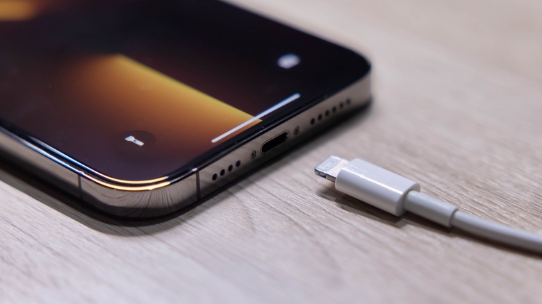 An iPhone charging cable next to an iPhone.