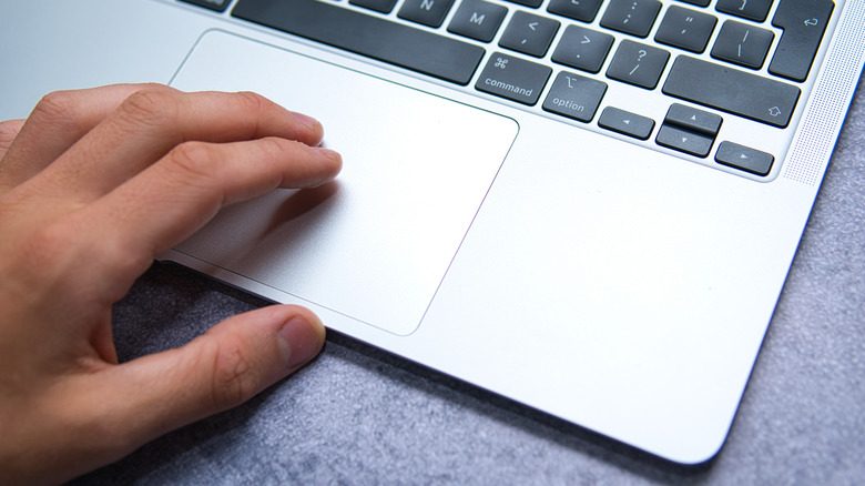 Person using trackpad on MacBook