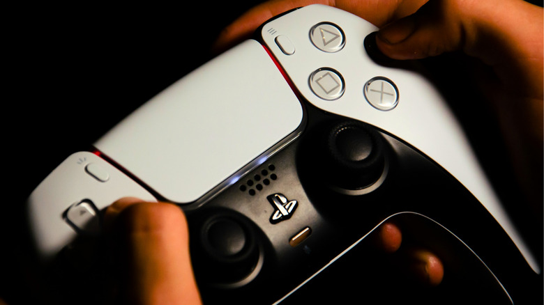 Close-up of a PS5 DualSense controller with light bars glowing orange