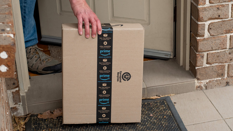 Man opening front door to pick up Amazon package