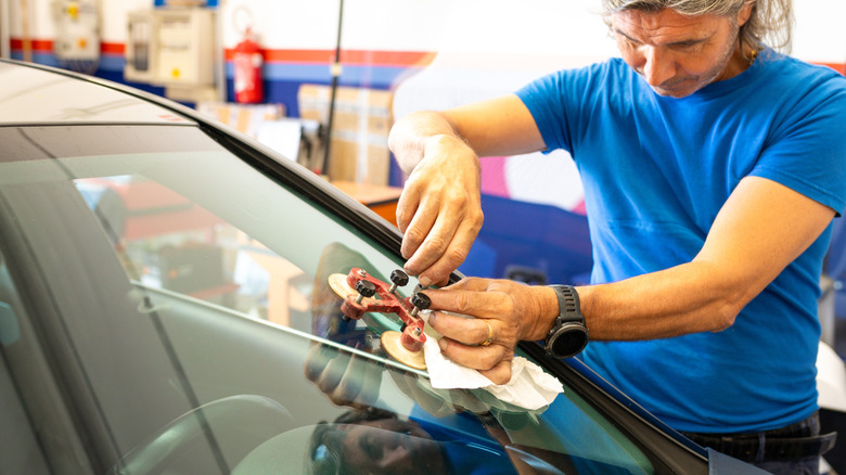 man fixing windshield at the garage