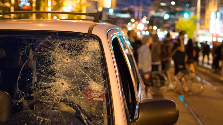 vandalism broken windshield on stret