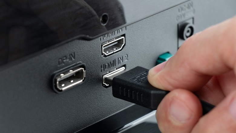 Person inserting HDMI cable