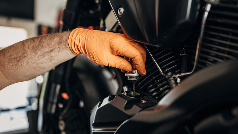 Person changing motorcycle oil