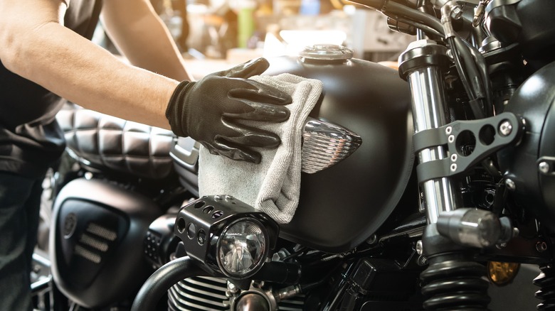 Person cleaning motorcycle