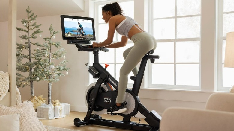 Woman watches display on a Nordic Track stationary bike