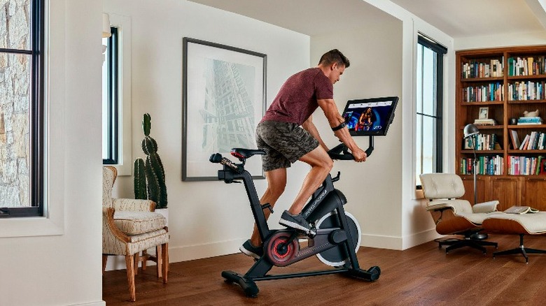 Man rides a Proform Studio Bike Pro 22 in the living room