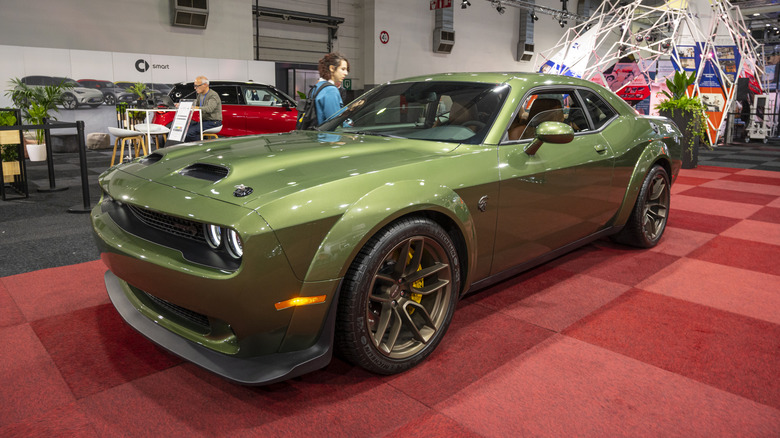 A Dodge Challenger SRT Hellcat Widebody in olive green, auto show, front 3/4 view