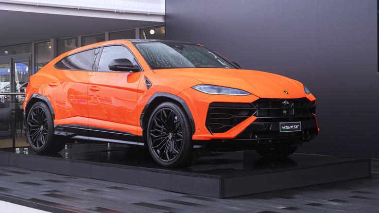 A Lamborghini Urus SE in orange on display, front 3/4 view