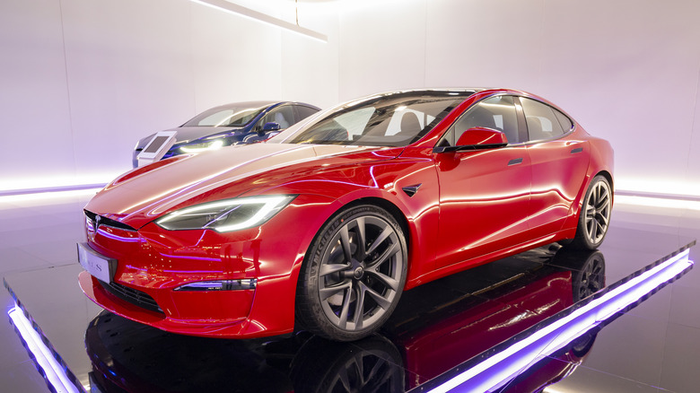 A Tesla Model S Plaid in red on display, front 3/4 view