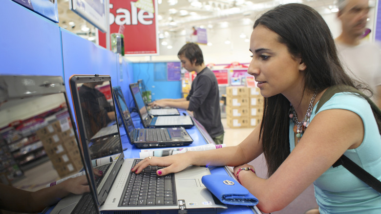 Woman browsing laptops in a store