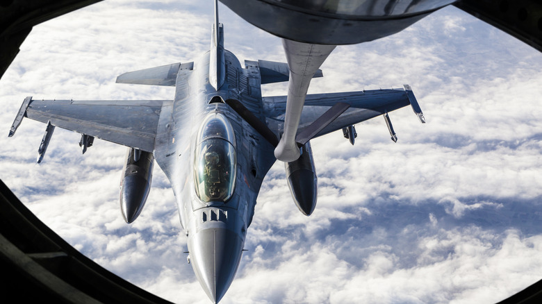 A fighter jet refuling mid-flight